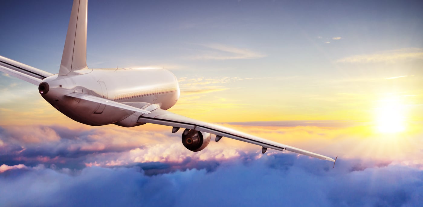 Commercial Airplane Flying Above Clouds